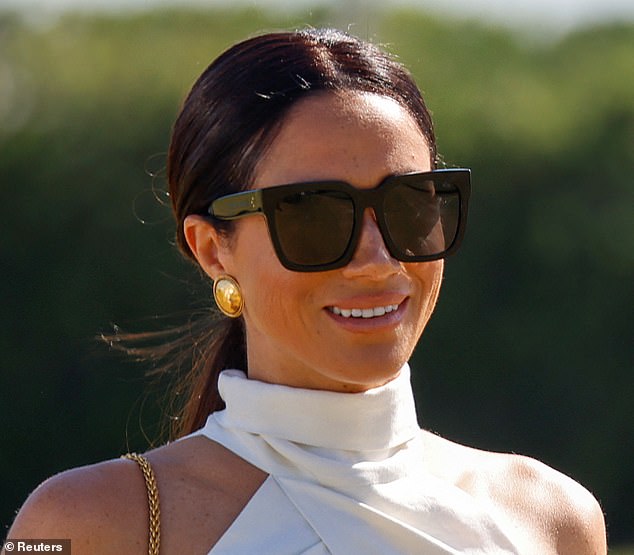 The Duchess of Sussex, 42, beamed with delight as she presented her husband with his trophy