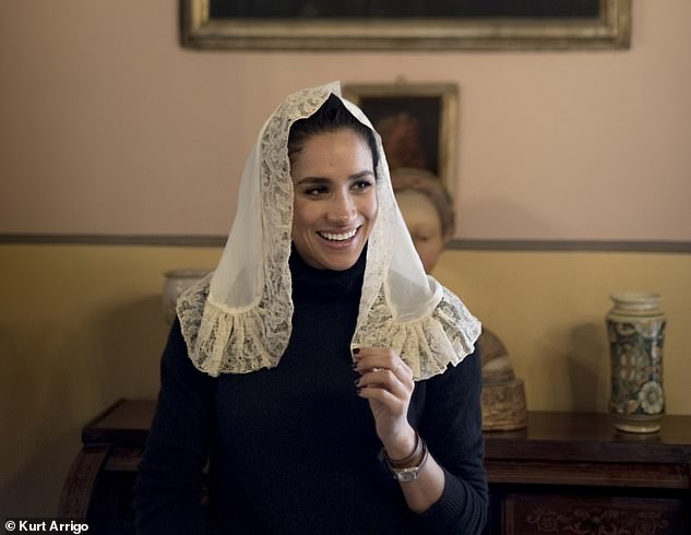 The future wife of Prince Harry also tries on a traditional white headdress, as might have been worn by her ancestors