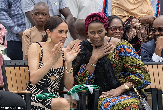 Meghan appeared in close conversation with her hosts as she watched Harry play, wearing a huge grin