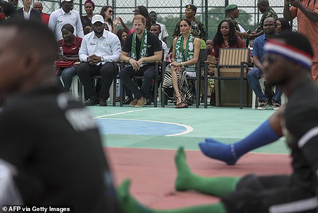 Harry and Meghan can be seen watching a volley ball game on the sidelines as they were surrounded by adoring fans