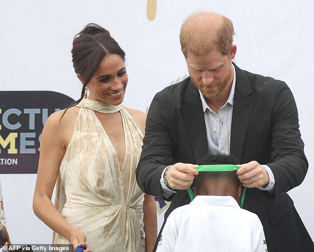 Prince Harry presents a medal after a charity polo game at the Ikoyi Polo Club in Lagos during the trip