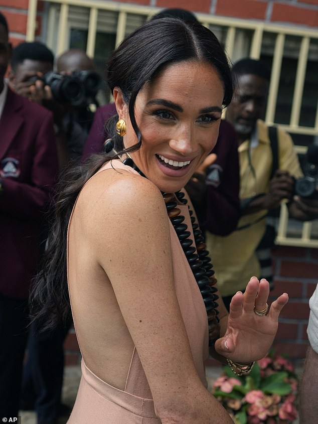 Meghan opted for a daring backless dress as she and Prince Harry kicked off their 72-hour whistlestop tour of Nigeria today with a trip to a school supported by the couple's Archewell Foundation