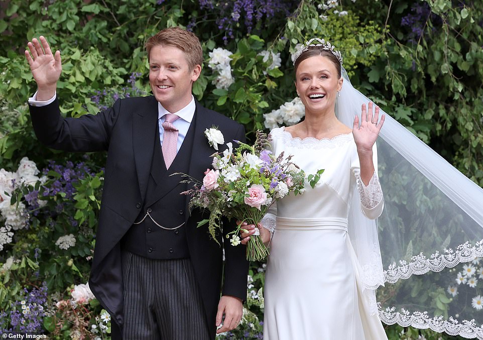 Hugh and Olivia smile and wave at the crowd after their wedding at Chester Cathedral today