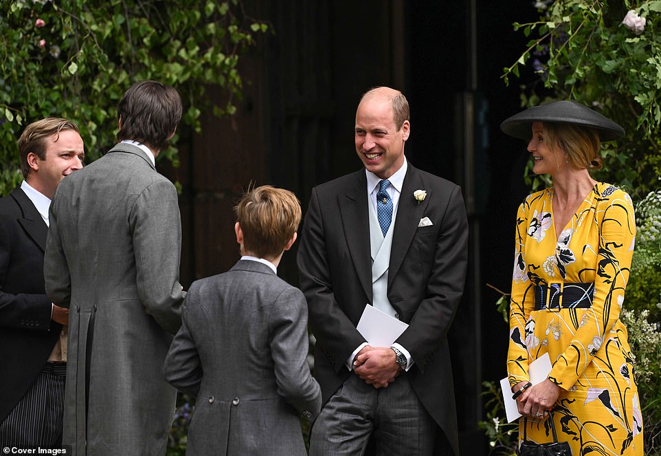 Prince William breaks into laughter as he stands alongside Rosie van Cutsem while chatting to guests