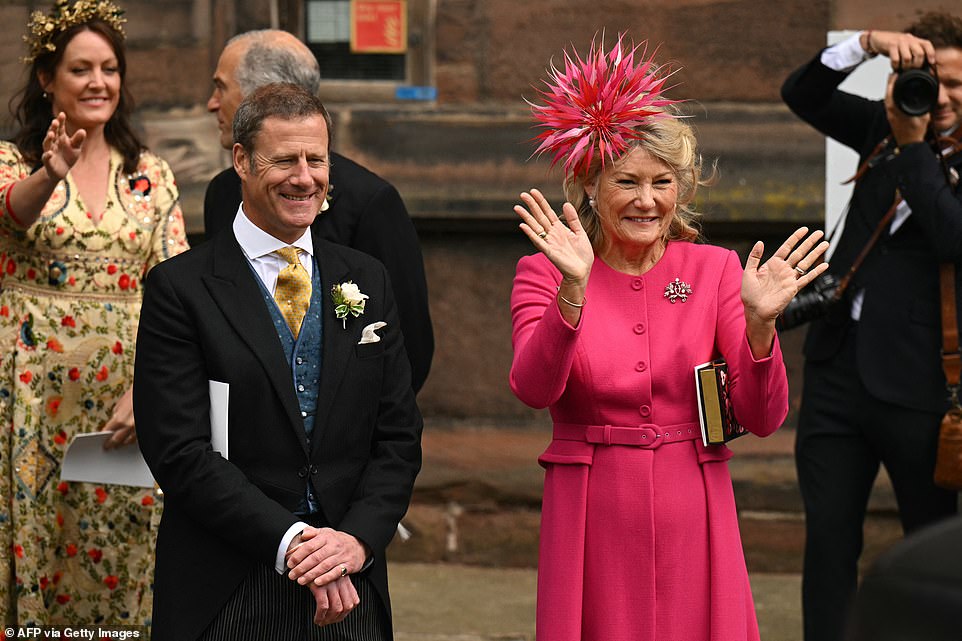 Natalia Grosvenor, Duchess of Westminster and mother of the groom, waves next to Rupert Henson, father of the bride, as Hugh Grosvenor and Olivia Henson leave Chester Cathedral