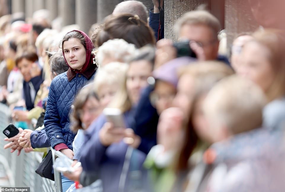 Well-wishers line the street ahead of the wedding today