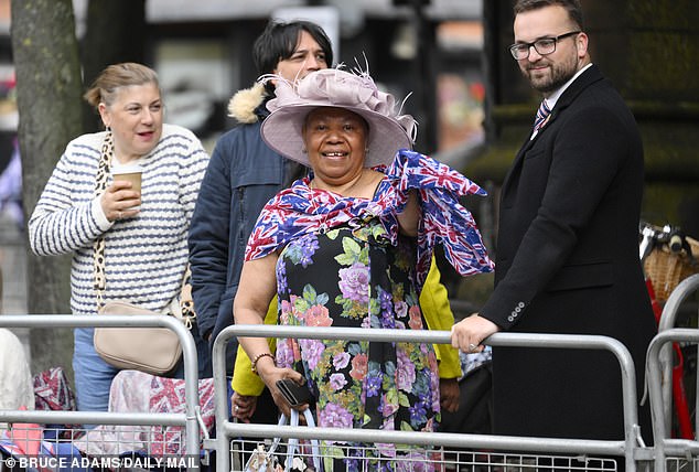 A woman dresses up in wedding attire and a Union Jack scarf outside the cathedral