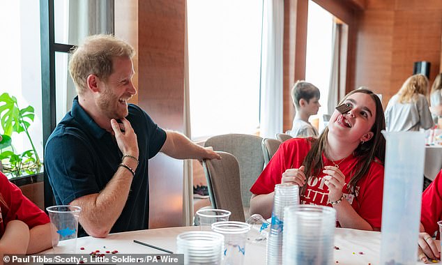 The Duke laughs at one of the girls trying to get a piece of chocolate off her face