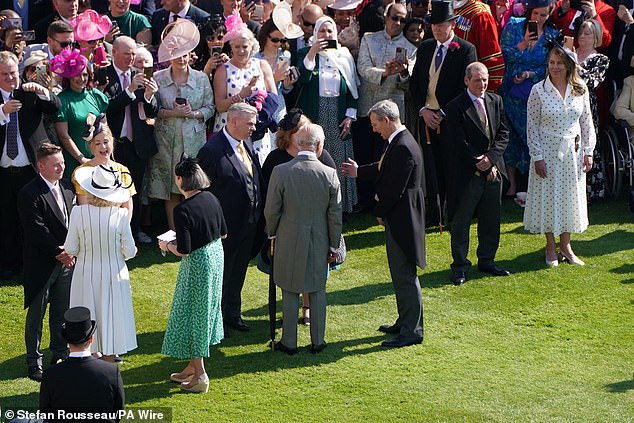 A row had broken out after a spokesman for Harry suggested Charles, pictured here mingling with guests at the garden party on May 8, had been 'too busy' to see Harry during his time in Britain