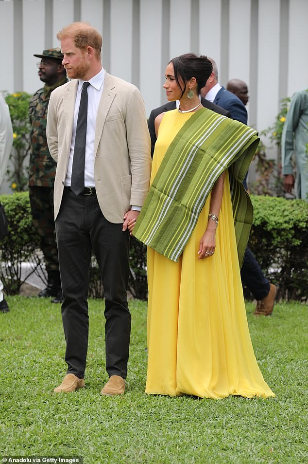 In Lagos, Meghan donned a very long Carolina Herrera Silk Overlay Column Gown in 'taxi cab' yellow