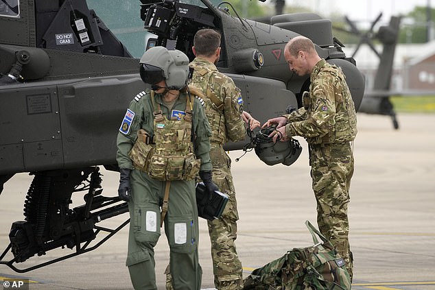 Prince William in front of an Apache helicopter at the Army Aviation Centre today