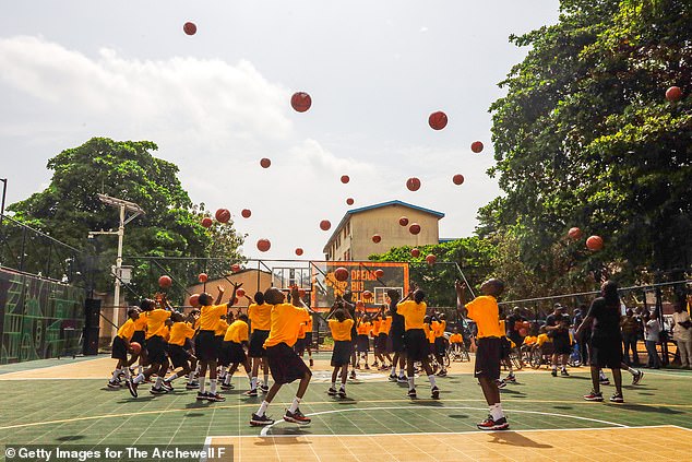 The Prince joined youngsters on a basketball court in his suit jacket to practice drills, throwing the ball in the air and dribbling it