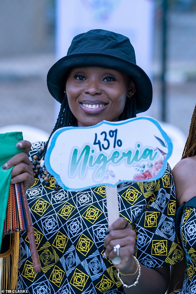 One adoring fan holds a sign reading 43% Nigerian in a nod to Meghan's recent admission of her west African heritage