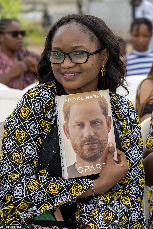 One adoring fan holds a copy of Harry's memoir spare - maybe she was lucky enough to get it signed by the Prince himself