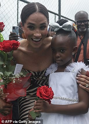 The Duchess joyfully posed with onlookers - including one young girl, dressed up smartly in a white dress and matching bow