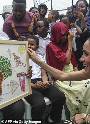 Meghan was left thrilled as she was presented with a painting by her adoring young fans