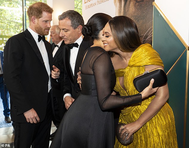 The Duchess of Sussex is seen  embracing Beyoncé at the European Premiere of Disney's The Lion King at the Odeon Leicester Square, London, with Prince Harry stood behind