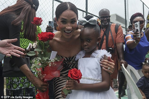 The Duchess joyfully posed with onlookers - including one young girl, dressed up smartly in a white dress and matching bow