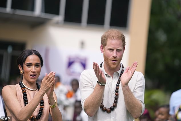 Harry and Meghan clap as they meet children at the Wuse Lightway Academy in Abuja today