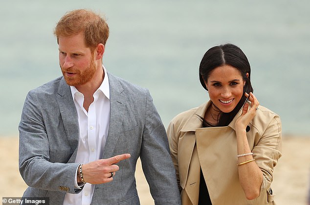 Prince Harry sporting the Oura ring at South Melbourne beach in 2018 with Meghan Markle - just months after their wedding in May.