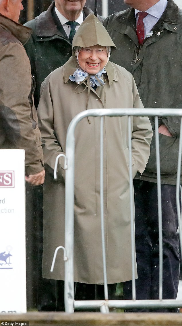 Queen Elizabeth II shelters from the rain with her hands in her pockets as she attends the Royal Windsor Horse Show in 2019