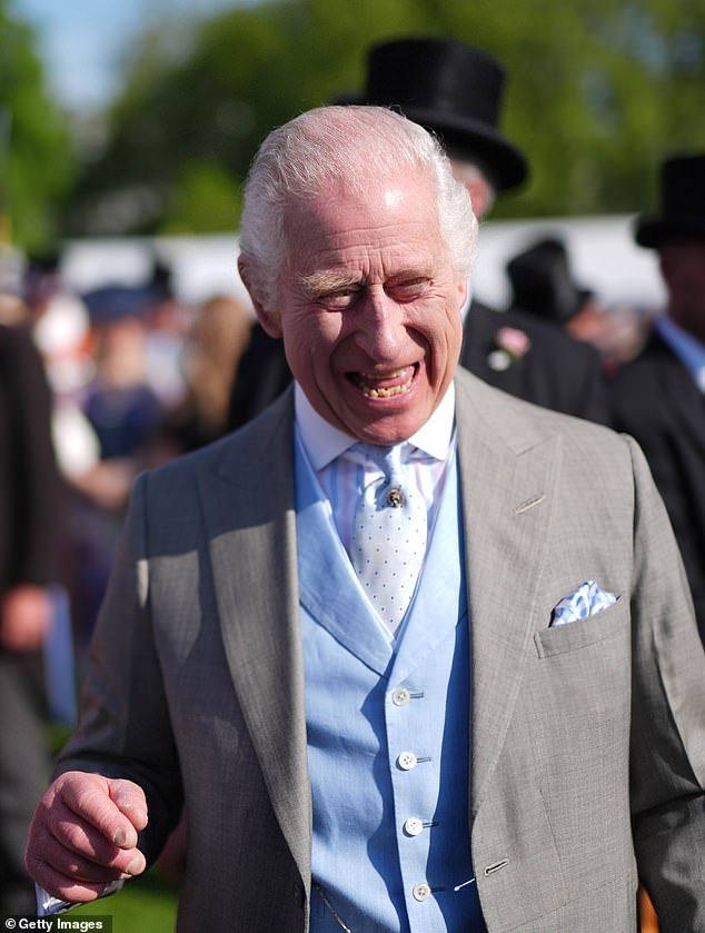 King Charles III speaks to guests attending a Royal Garden Party at Buckingham Palace on the same day as Harry was in the UK