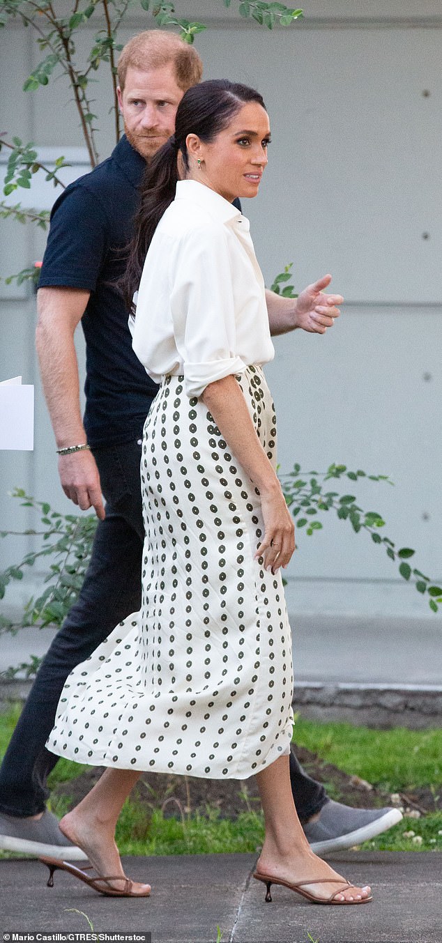 Harry and Meghan each changed clothes between their morning and afternoon engagements. Juan De Dios Amaime silk martello midi skirt in ivory green chintz, £347. Sarah Hendler spear dangle stud earrings in emerald and sapphires - £1,733