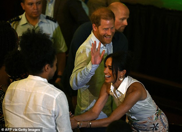 Harry and Meghan greet people on arrival to the Afro women and power debate