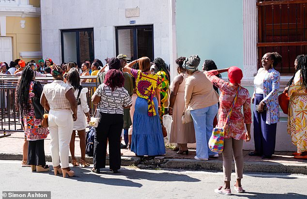 Hundreds gathered outside the heavily-guarded theatre before Meghan gave her speech while Harry sat in the audience