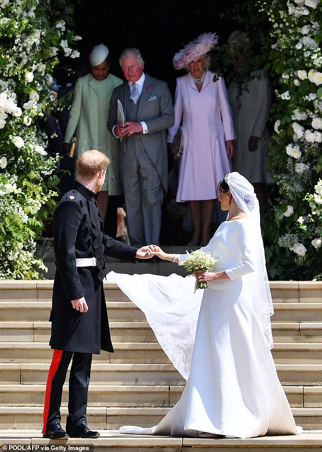 Prince Harry and Meghan on their wedding day looking back towards their family as Doria, Charles and Camilla leave the chapel