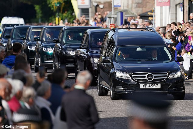 Members of the public gather in Banchory, Aberdeenshire, to watch the cortege carrying Queen Elizabeth's coffin drive past