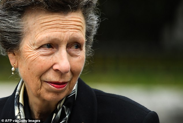 Princess Anne looks at flowers left outside of Balmoral Castle in tribute to her mother, the Queen