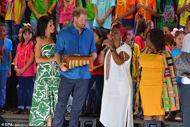 The Duke and Duchess of Sussex receive an award from singer Nidia Gongora (pictured here second from the right) during the closing of the festival