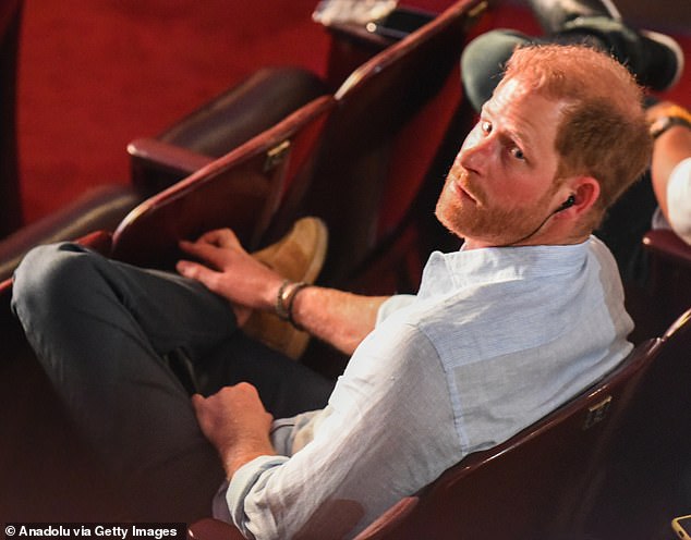 Prince Harry looks back while in the audience to watch his wife Meghan speak at a talk on 'Afro women and power'