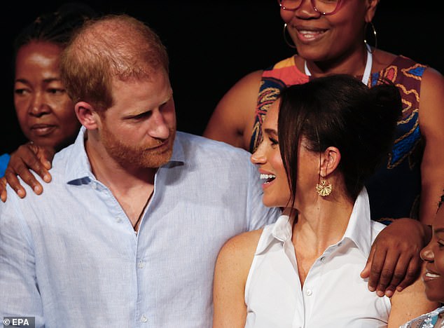 Harry looks adoringly at his wife Meghan who smiles warmly back during the conference