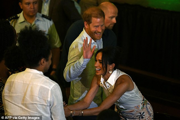 Meghan completed her look with a pair of gold statement earrings and Princess Diana's £17,800 Gold Tank Française Watch