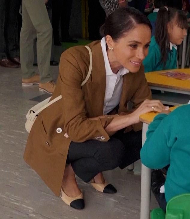 She also carried a small beige handbag over her shoulder, with some simple gold jewelry on her wrist