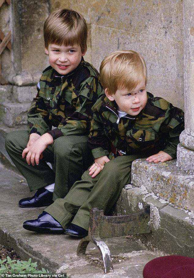 Prince Harry and Prince William sit together on the steps of Highgrove House wearing army uniforms in July 1986