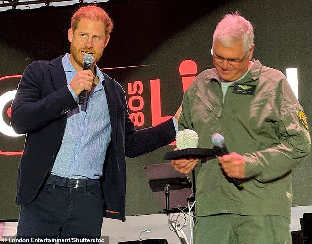 Prince Harry presents an award to Helicopter Pilot /first responder Loren Courtney on Saturday