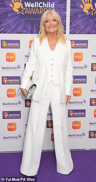 Gabby Roslin looked effortlessly stylish in a white three-piece suit while toting her essentials in a silver clutch