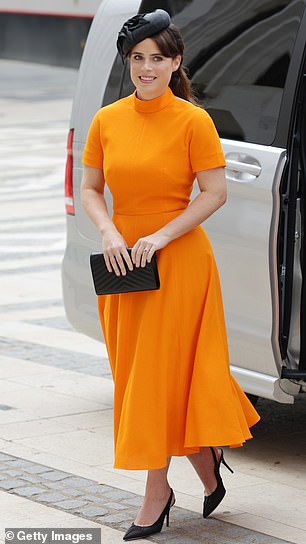 Princess Eugenie appeared at the service wearing a flowing orange dress with a black hat and matching high heels