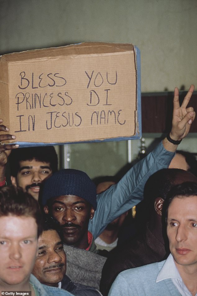 A man holding up a cardboard placard with the words, 'Bless you Princess Di in Jesus name' at Harlem Hospital