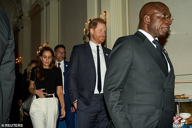 Harry walks behind Angolan Foreign Minister Tete Antonio (right) as they depart the Halo Trust event