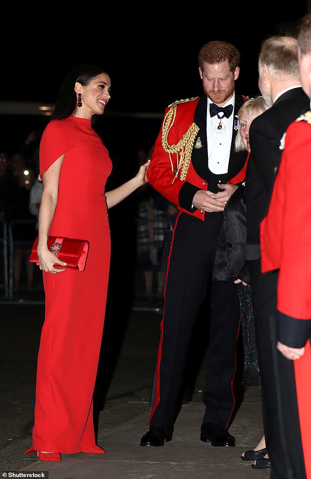 Meghan places a hand behind Harry at the Mountbatten Festival of Music in 2020