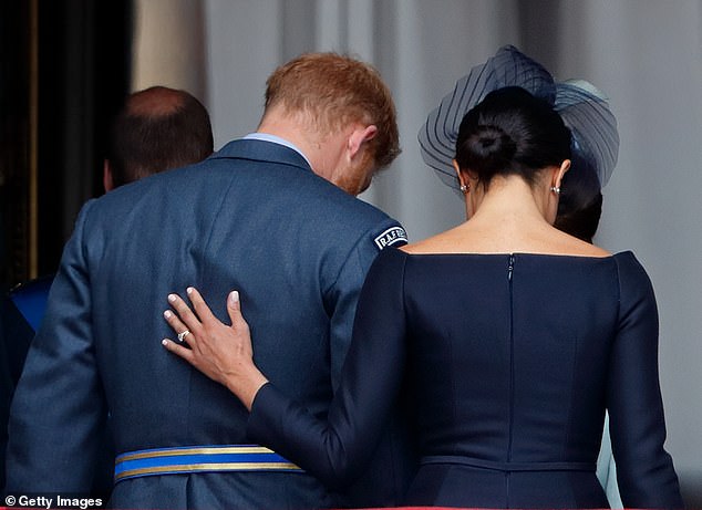 Meghan placing a reassuring hand on her husband's back after watching the RAF centenary flypast in 2018