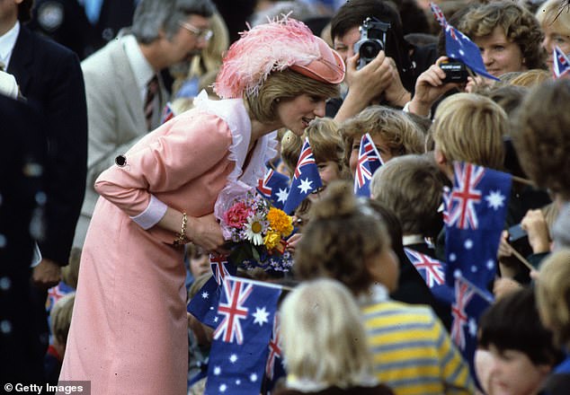 Diana, wearing a peach-coloured dress designed by Bellville Sassoon, is greeted by the public during a walkabout on March 25, 1983, in Canberra