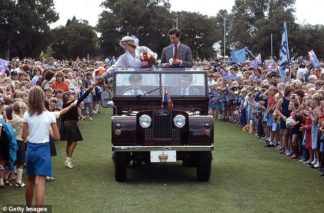 The couple stood riding a Land Rover at the Hands Oval sports ground in Western Australia as Diana accepts gifts from children