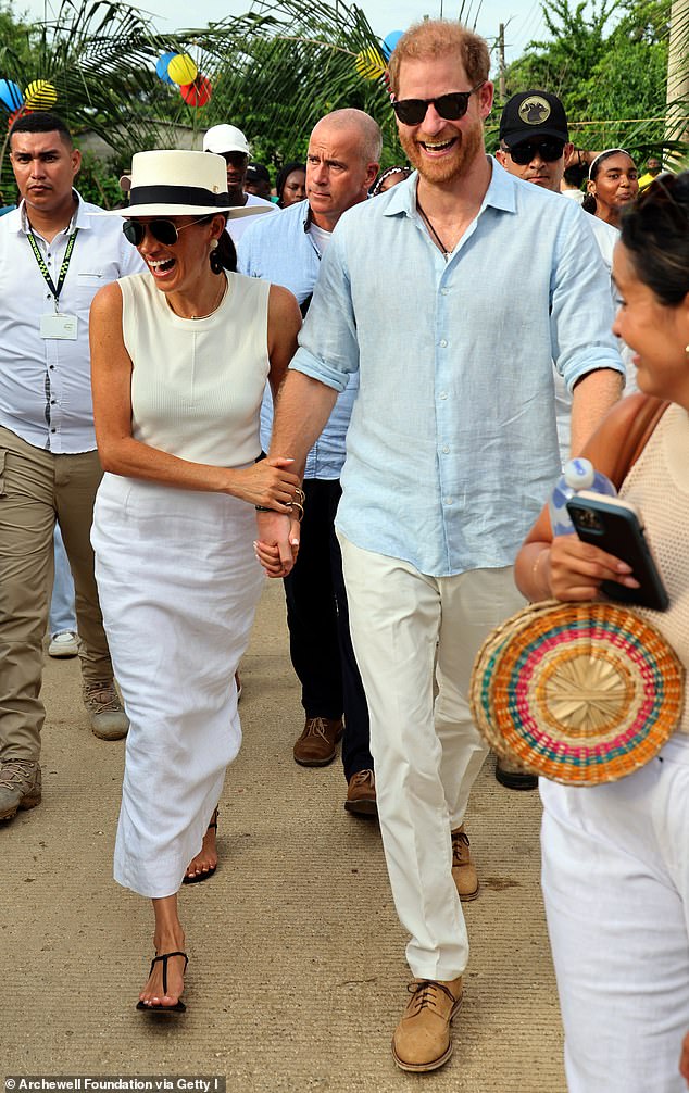 The outing proves it's not just her husband Prince Harry she can caress in public (pictured on their tour to Colombia in August)