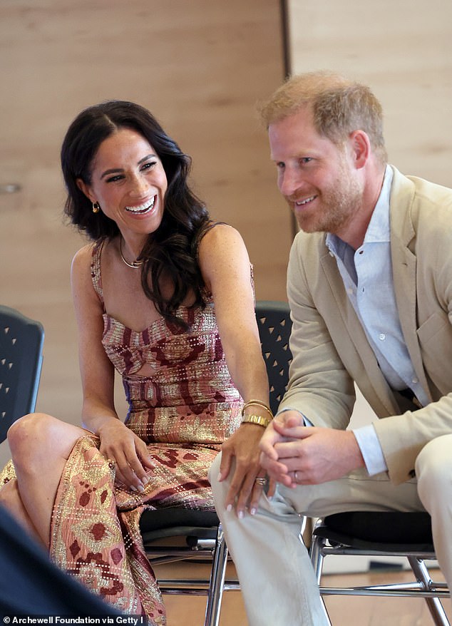 Meghan Markle smiles as she touches Prince Harry's knee during their visit to Colombia last month