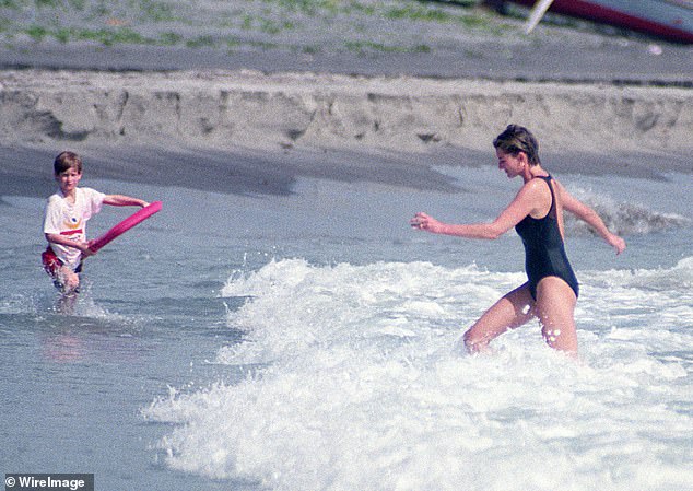 The late Princess of Wales wading through the waves towards Harry who is holding a board